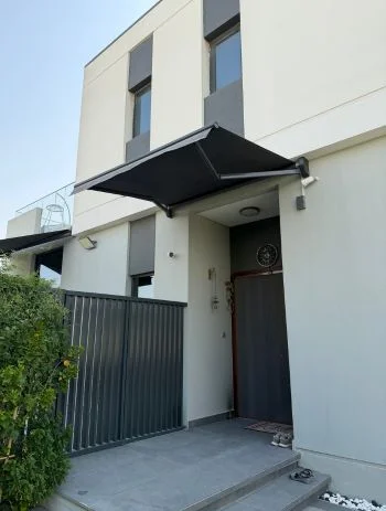 Orange retractable awning shading an outdoor terrace